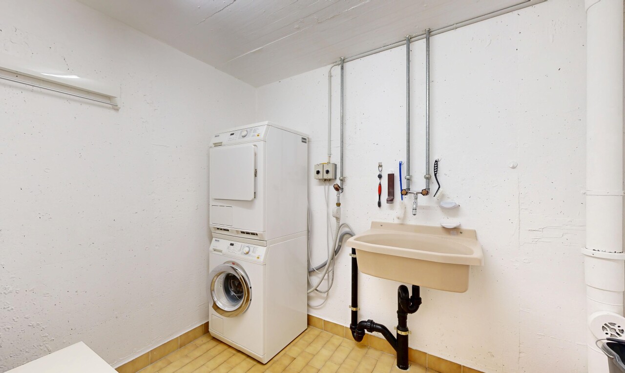 laundry room featuring stacked washer and clothes dryer and baseboards