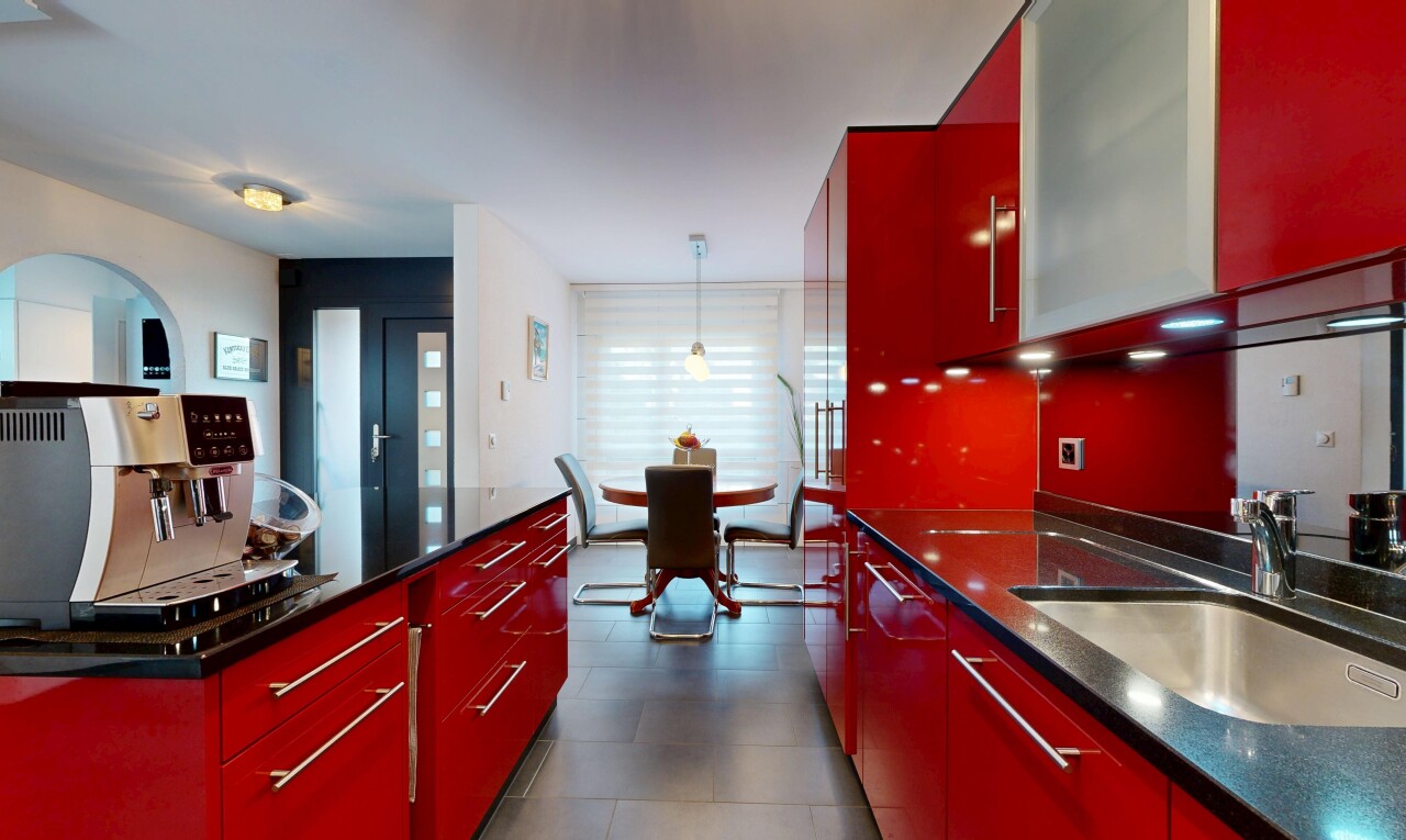 kitchen with red cabinets, modern cabinets, and dark stone countertops