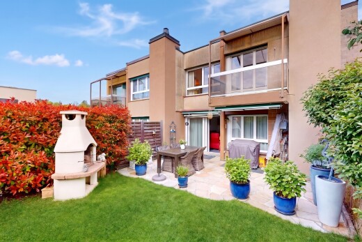view of home featuring stucco siding, a balcony, a yard, a patio, and a chimney