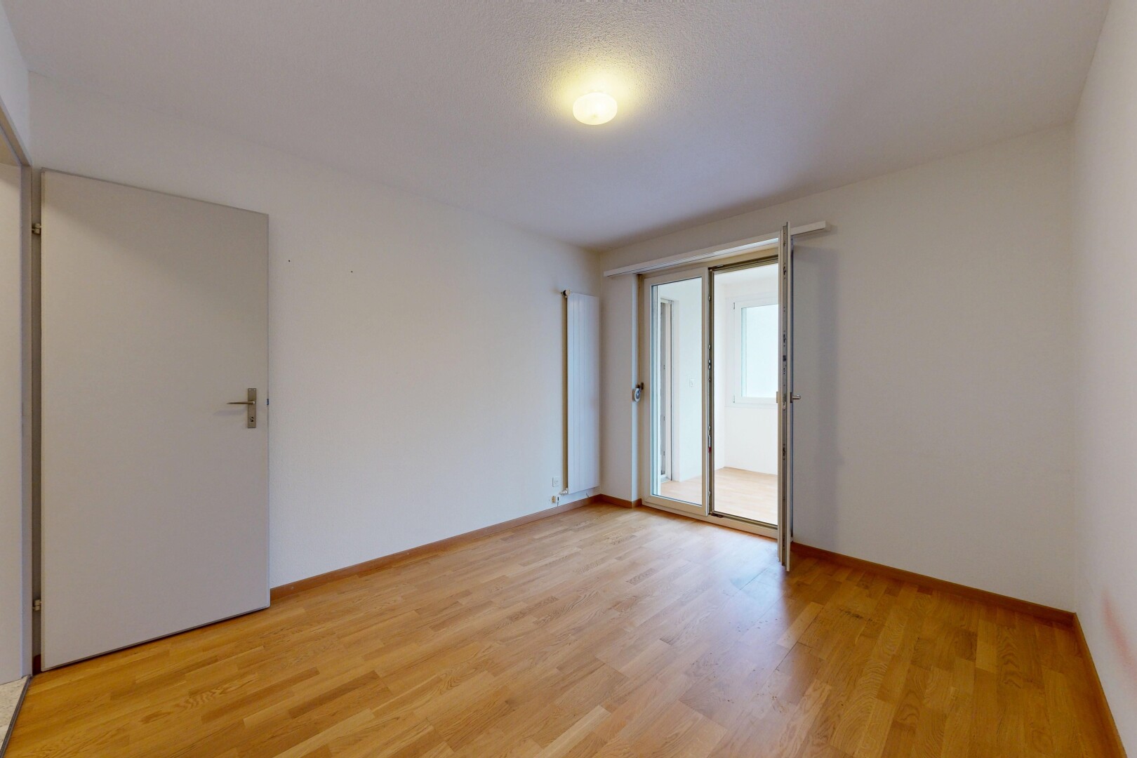 pièce vide avec cloison sèche, drywall, sol en finition bois, wood finish floor, et lumière naturelle