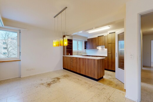 kitchen with a peninsula, light countertops, pendant lighting, open shelves, and brown cabinets
