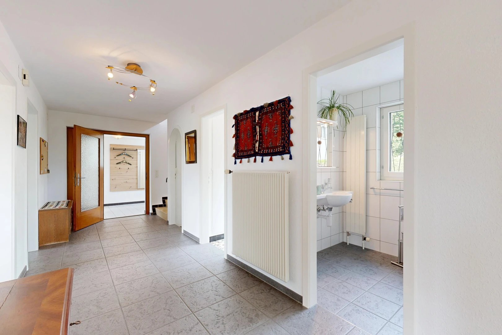 couloir avec radiateur, light floor, cloison sèche, drywall, et inside property