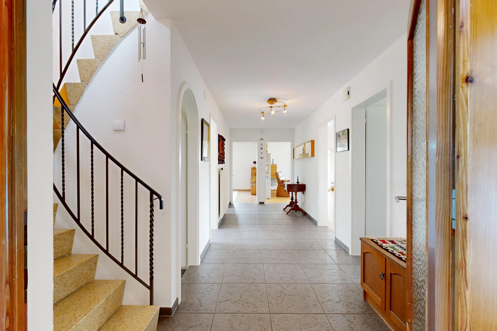 couloir avec escaliers, carpet stairs, passages en arc, drywall, et cloison sèche