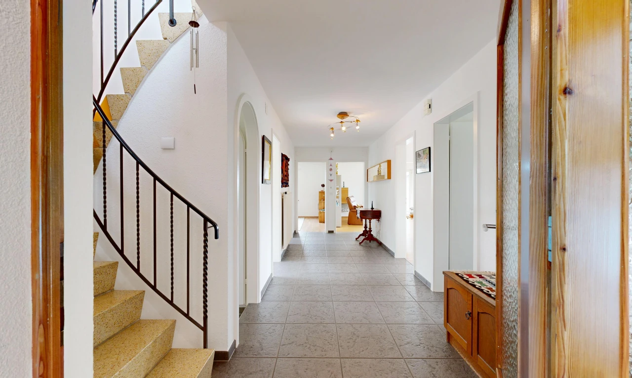 couloir avec escaliers, carpet stairs, passages en arc, drywall, et cloison sèche