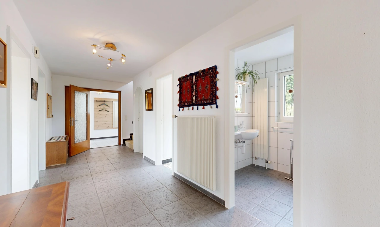couloir avec radiateur, light floor, cloison sèche, drywall, et inside property