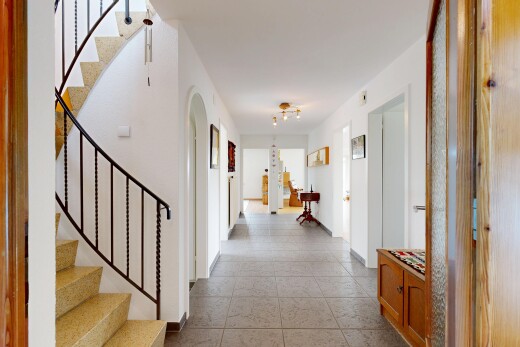 couloir avec escaliers, carpet stairs, passages en arc, drywall, et cloison sèche