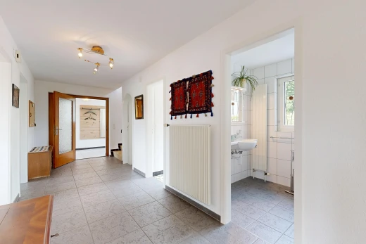 couloir avec radiateur, light floor, cloison sèche, drywall, et inside property