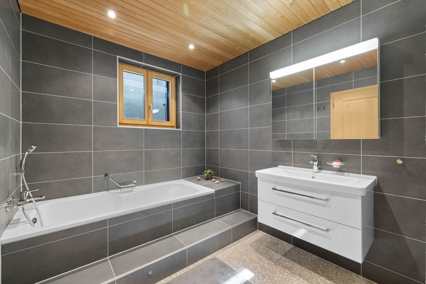 salle de bains avec tile wall, mur en carrelage, miroir, lavabo (ou coiffeuse selon le contexte), et salle de bain complète