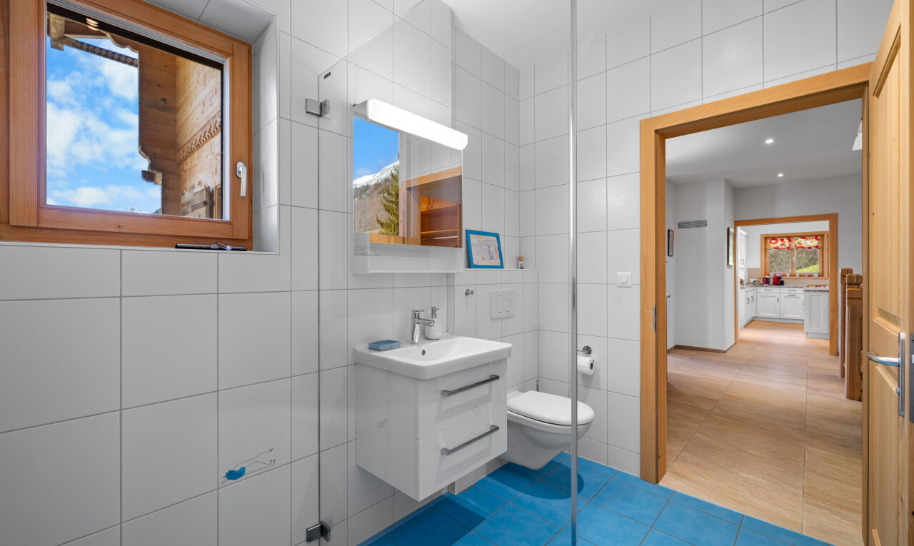 salle de bains avec tile wall, mur en carrelage, lavabo (ou coiffeuse selon le contexte), natural light, et lumière naturelle