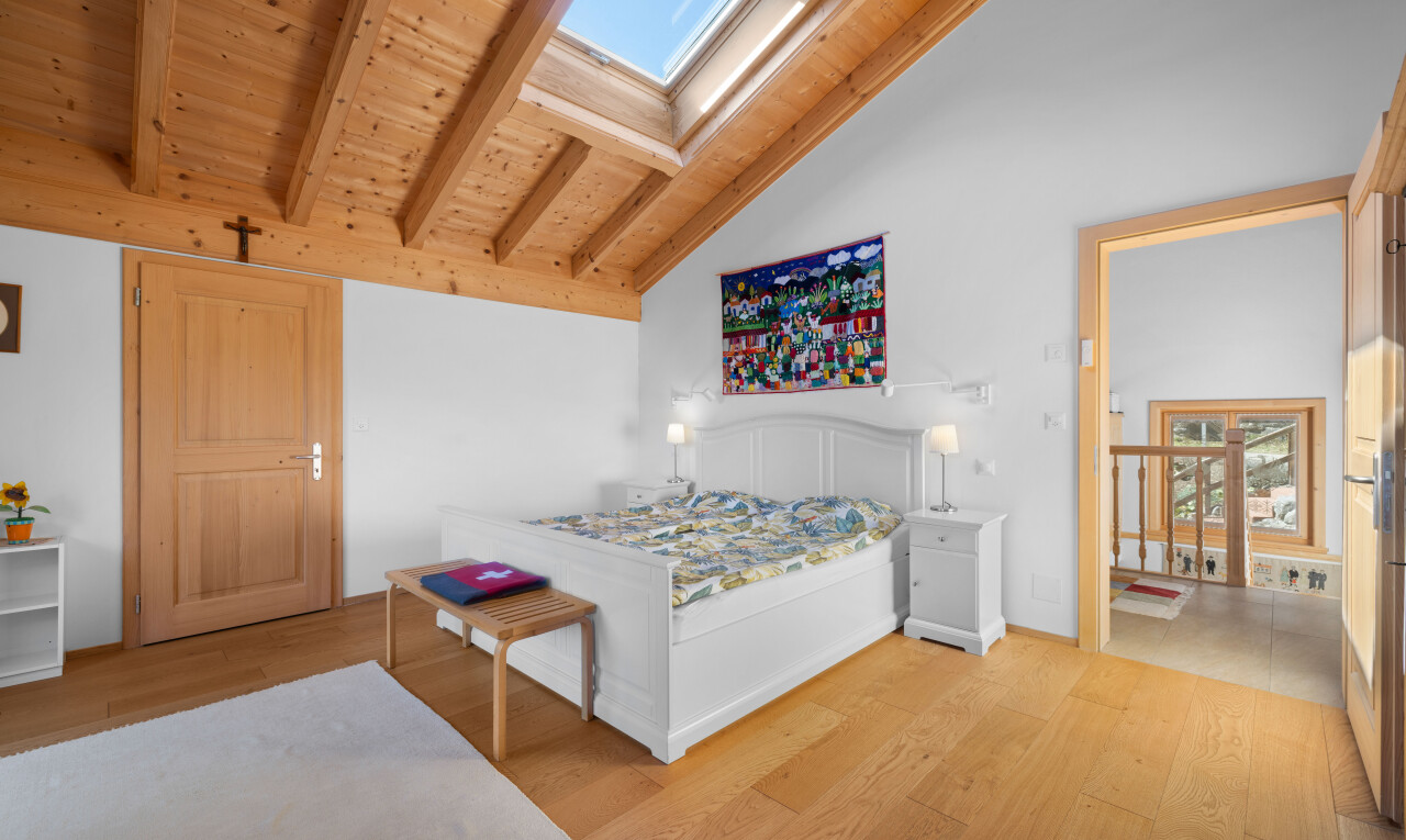 chambre avec beamed ceiling, plafond à poutres, puits de lumière, wood finish floor, et sol en finition bois