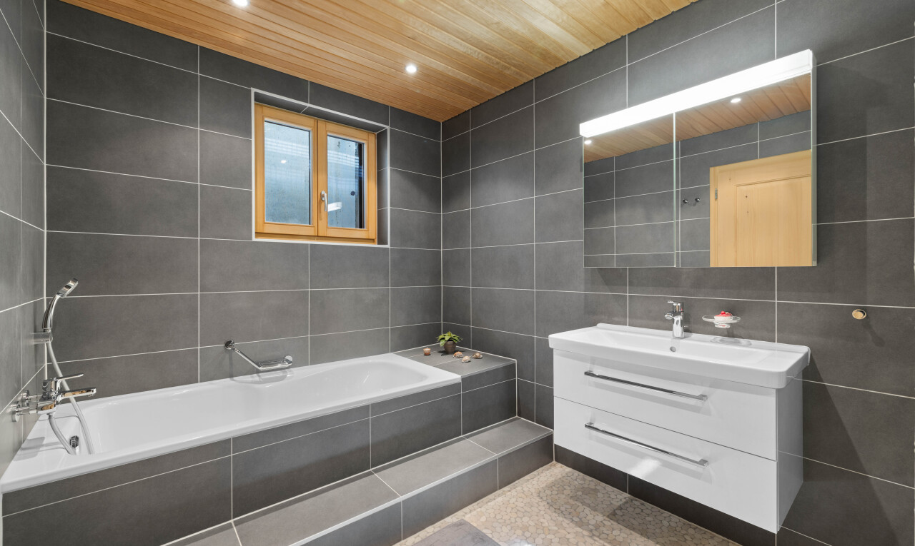 salle de bains avec tile wall, mur en carrelage, miroir, lavabo (ou coiffeuse selon le contexte), et salle de bain complète