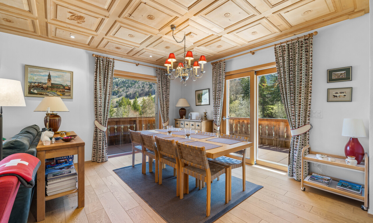 salle à manger avec wood finish floor, sol en finition bois, drywall, cloison sèche, et lustre remarquable