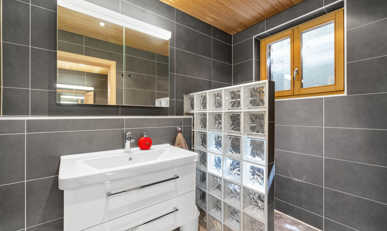salle de bains avec tile wall, mur en carrelage, lavabo (ou coiffeuse selon le contexte), inside property, et miroir
