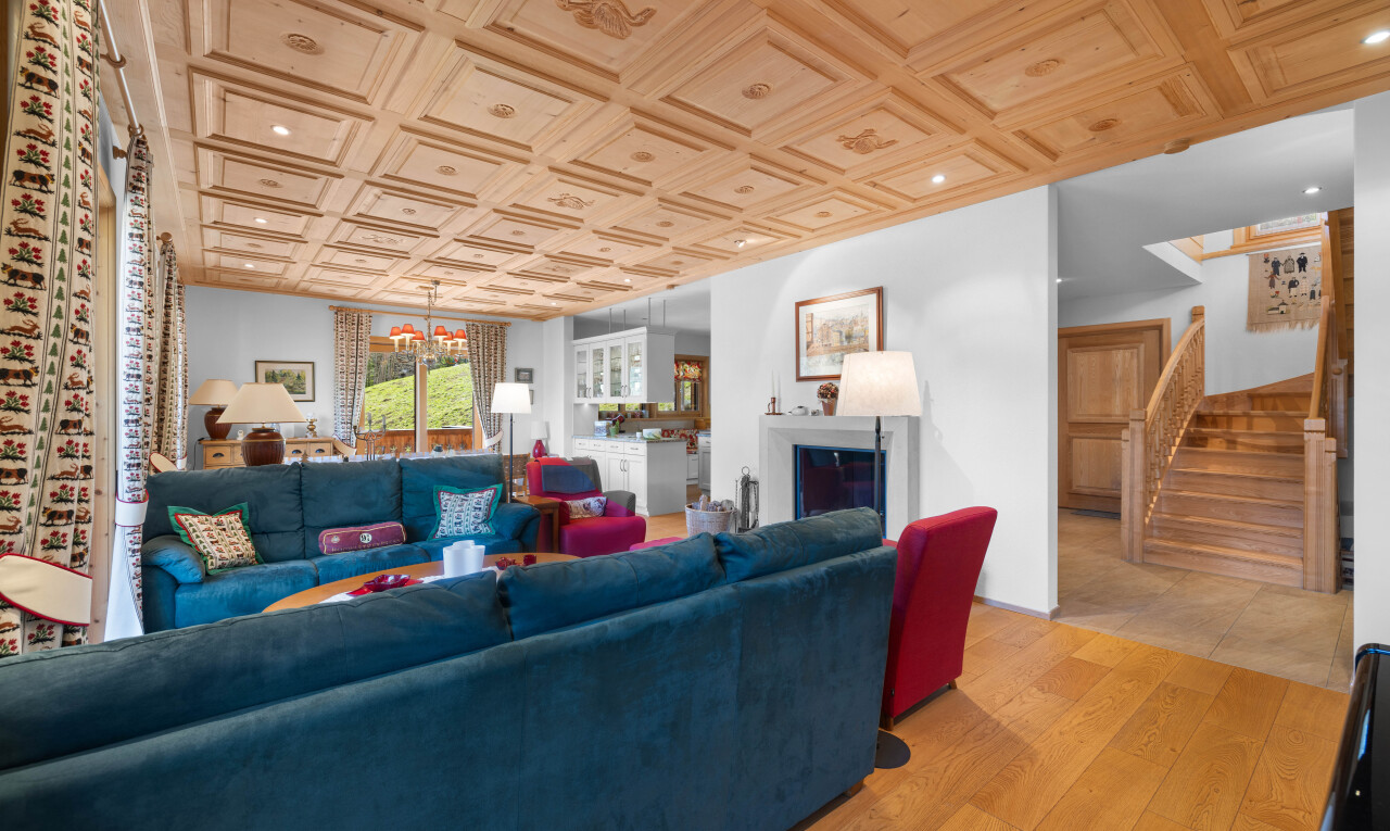 salon avec escaliers, lustre remarquable, wood finish floor, sol en finition bois, et cheminée