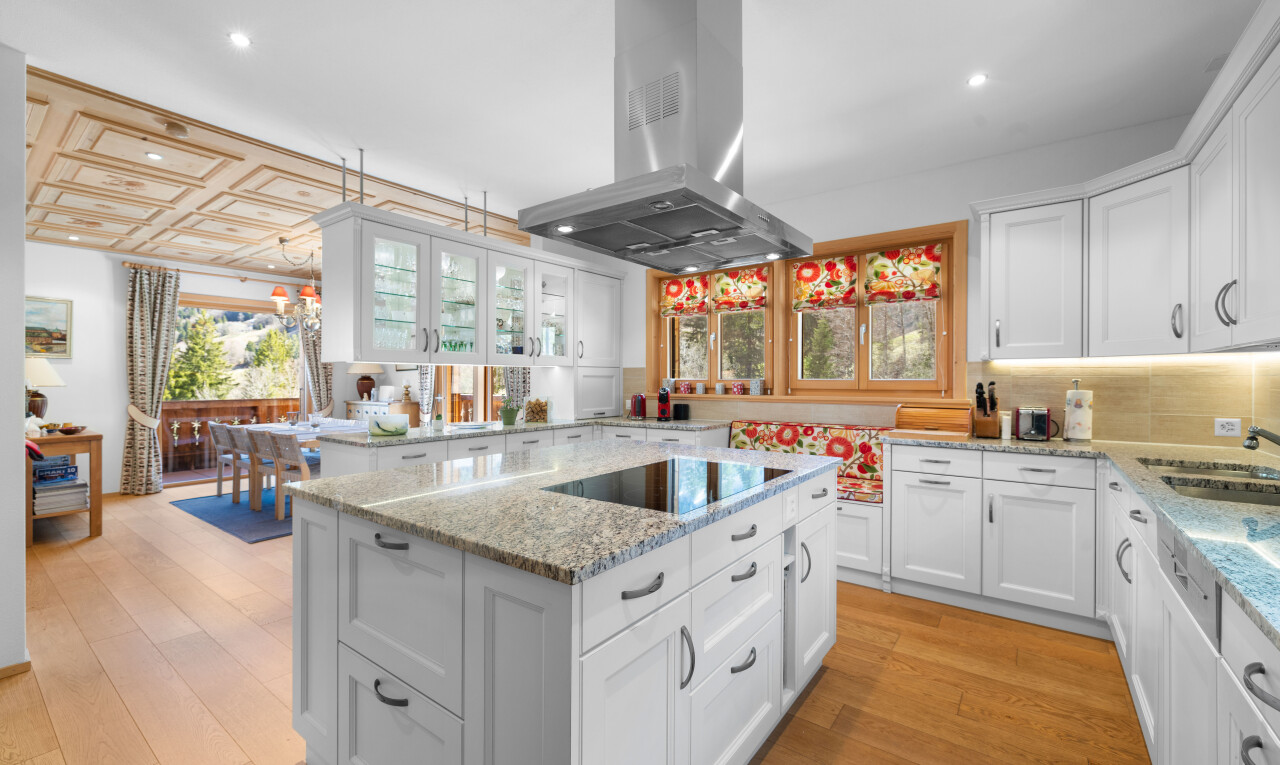 cuisine avec armoires blanches, white cabinets, plans de travail en pierre, stone countertops, et light countertops
