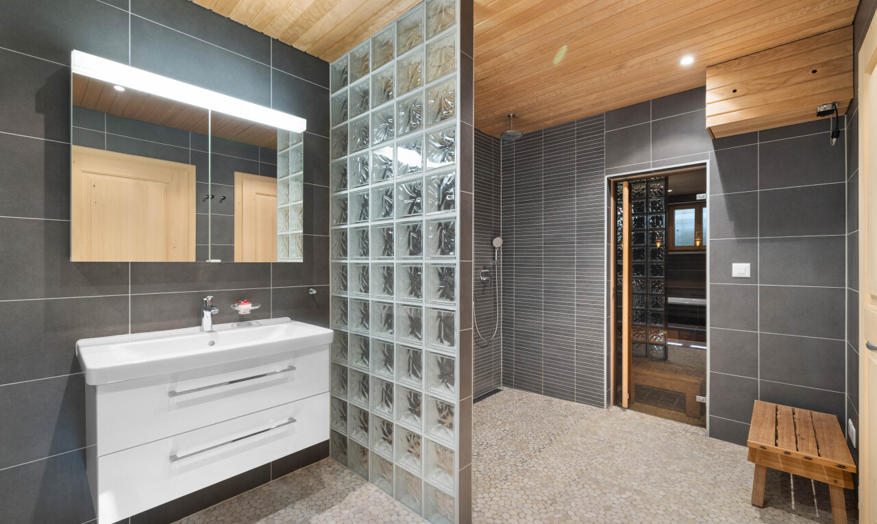 salle de bains avec tile wall, mur en carrelage, lavabo (ou coiffeuse selon le contexte), miroir, et salle de bain complète
