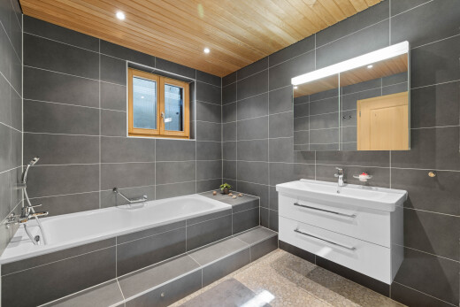 salle de bains avec tile wall, mur en carrelage, miroir, lavabo (ou coiffeuse selon le contexte), et salle de bain complète