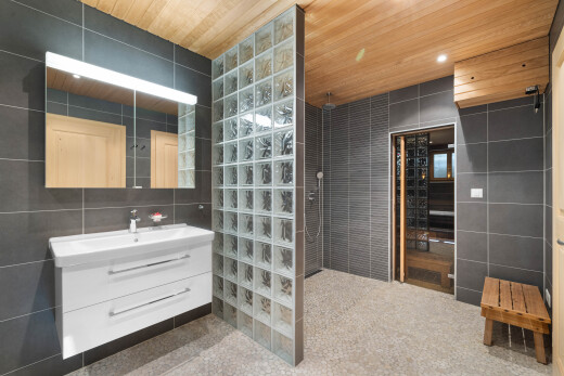 salle de bains avec tile wall, mur en carrelage, lavabo (ou coiffeuse selon le contexte), miroir, et salle de bain complète