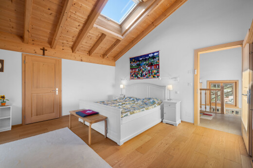 chambre avec beamed ceiling, plafond à poutres, puits de lumière, wood finish floor, et sol en finition bois