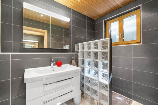 salle de bains avec tile wall, mur en carrelage, lavabo (ou coiffeuse selon le contexte), inside property, et miroir