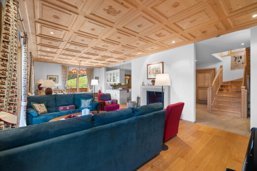 salon avec escaliers, lustre remarquable, wood finish floor, sol en finition bois, et cheminée