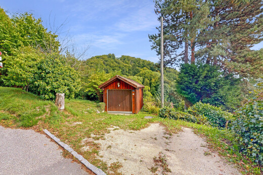 view of property featuring a view of trees and a shed