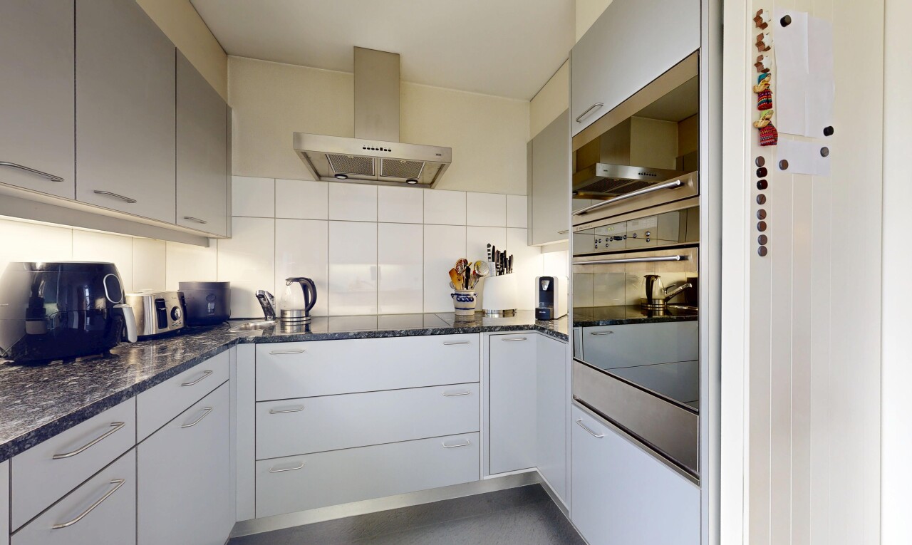 küche mit dunstabzugshaube, dark countertops, ofen, küchenrückwand beim Herd, und küchenrückwand beim herd