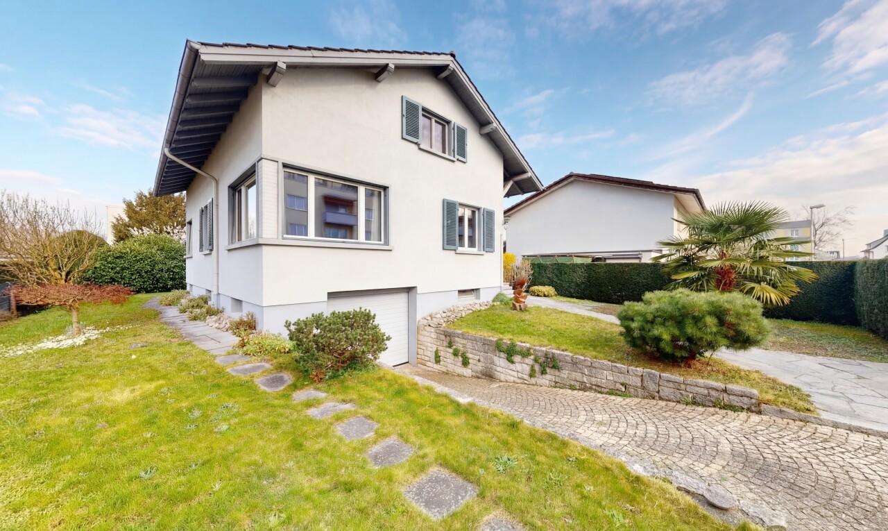 außenansicht mit rasen, stuckverkleidung, property visible, eingebaute garage, und kellergarage