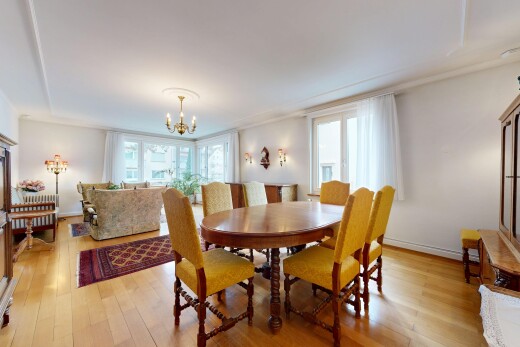 salon / salle à manger avec sol en finition bois, wood finish floor, cloison sèche, drywall, et lustre remarquable