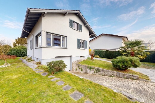 außenansicht mit rasen, stuckverkleidung, property visible, eingebaute garage, und kellergarage