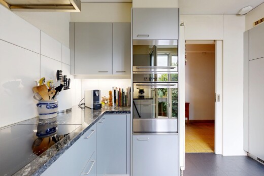 cuisine avec dark countertops, four, plaque de cuisson, gray cabinets, et armoires grises