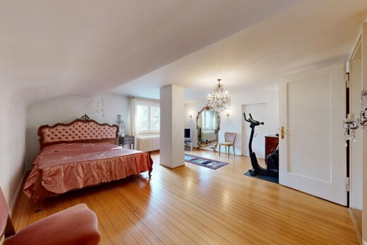 zimmer / schlafzimmer mit bemerkenswerter kronleuchter, inside property, wood finish floor, holzfußboden, und natural light