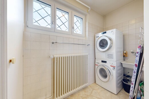 buanderie avec radiateur, lave-linge et sèche-linge superposés, inside property, tile wall, et mur en carrelage