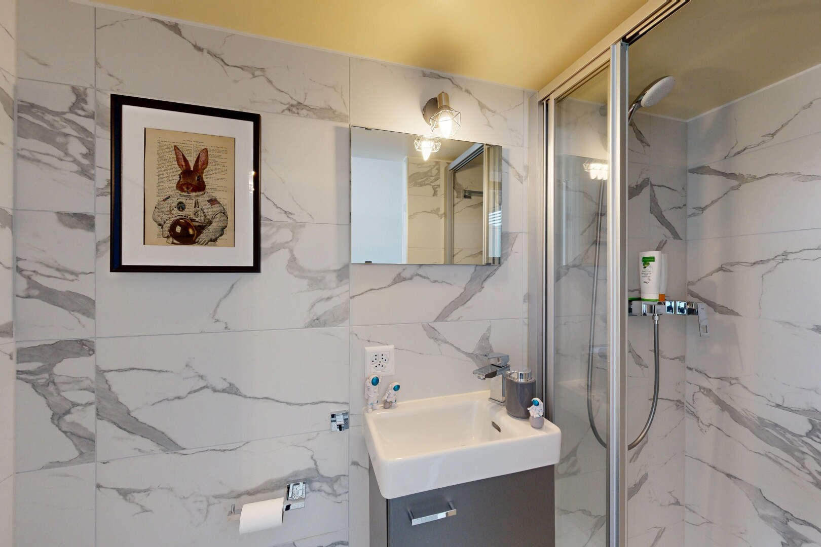 salle de bains avec lavabo (ou coiffeuse selon le contexte), miroir, douche, salle de bain complète, et évier