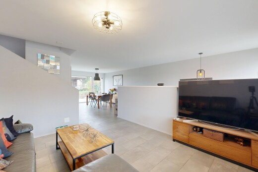salon avec télévision, cloison sèche, drywall, lumière naturelle, et natural light