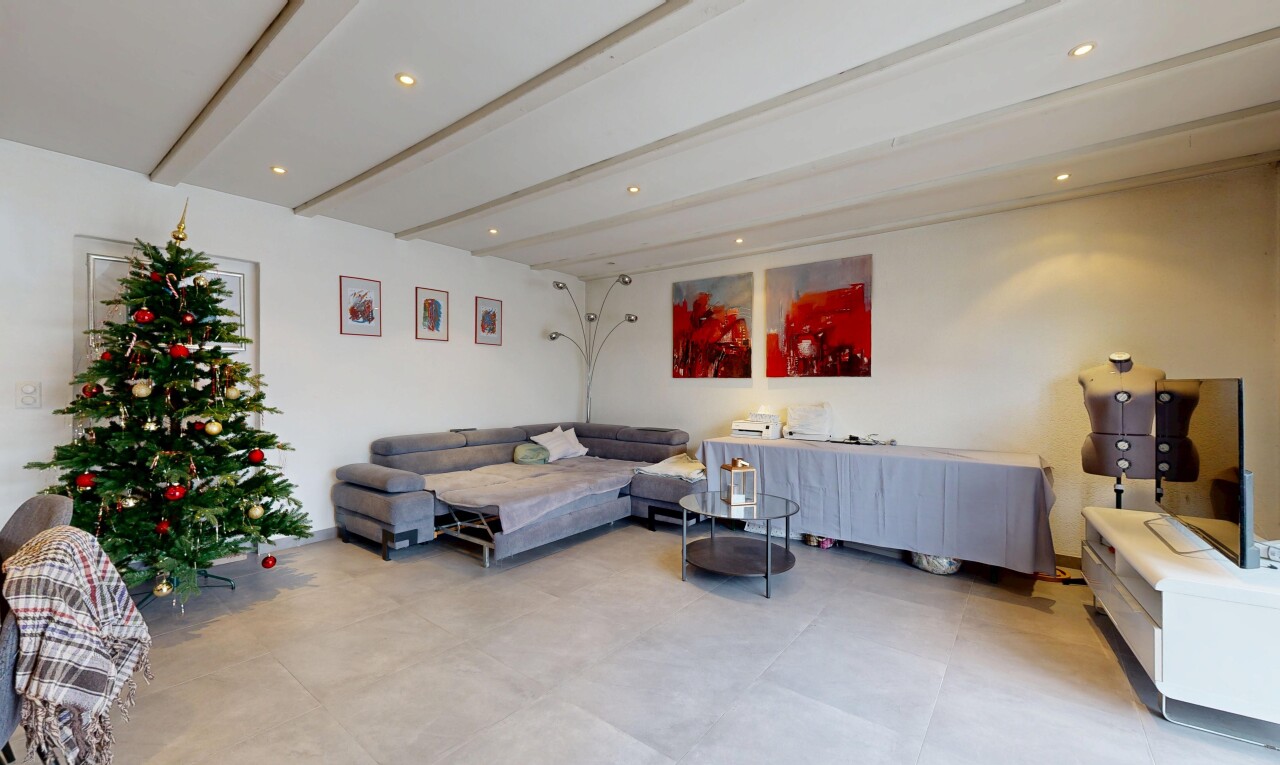 salon avec beamed ceiling, plafond à poutres, drywall, cloison sèche, et inside property