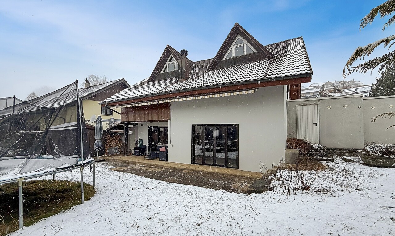façade avec trampoline, clôture, toit en tuiles, bardage en stuc, et property visible