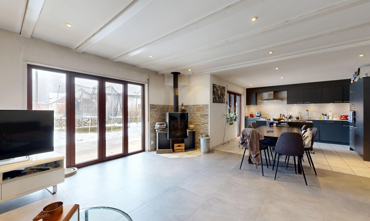 salon / salle à manger avec inside property, télévision, natural light, lumière naturelle, et poêle à bois