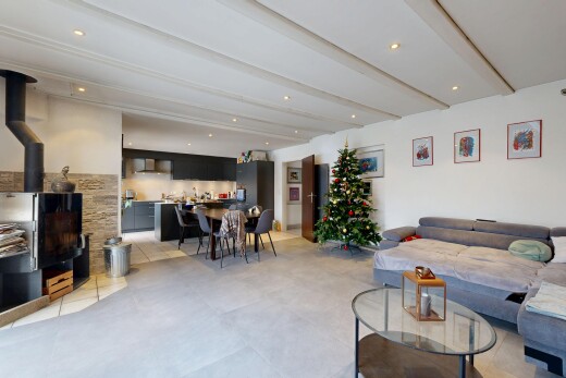living area featuring beamed ceiling, a wood stove, and recessed lighting