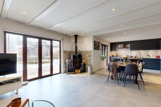 living / dining room featuring a wood stove, beam ceiling, and recessed lighting