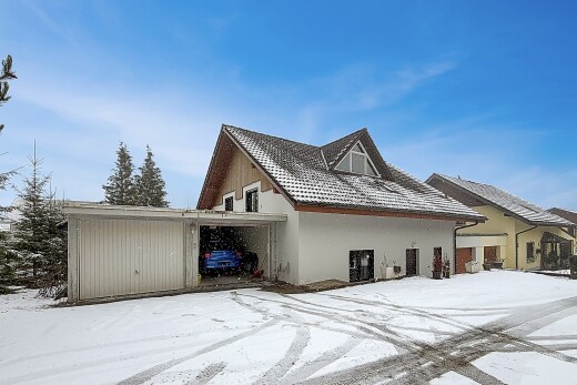 snow covered house with stucco siding