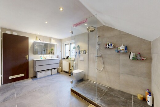 full bath featuring lofted ceiling, vanity, a walk in shower, and light tile patterned flooring