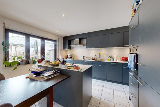 kitchen with modern cabinets, oven, a kitchen island, light tile patterned flooring, and light countertops