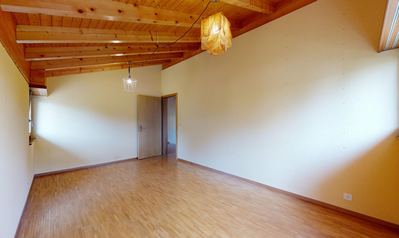 pièce vide avec drywall, cloison sèche, éclairage suspendu, beamed ceiling, et plafond à poutres
