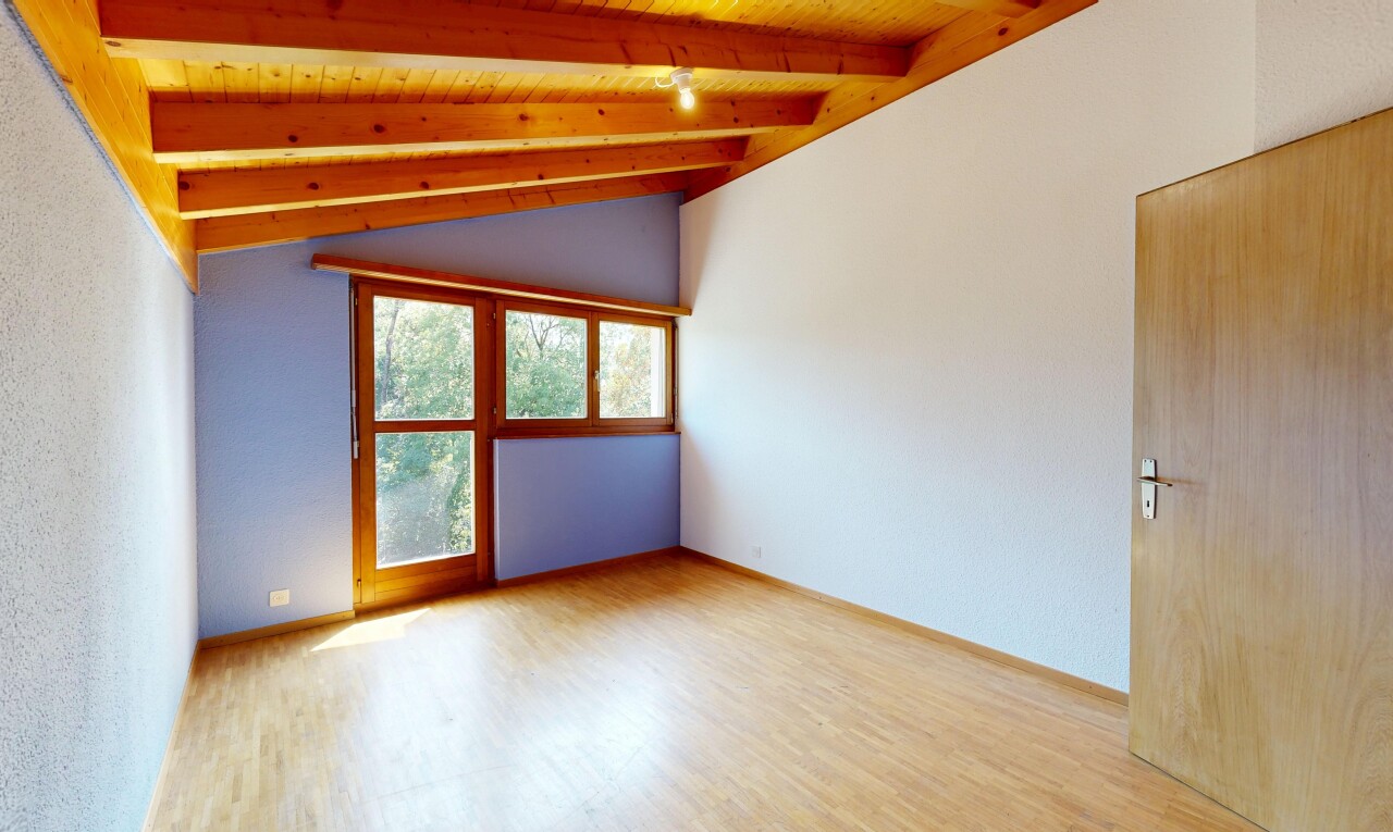 pièce vide avec vaulted ceiling, plafond voûté, wood finish floor, sol en finition bois, et beamed ceiling