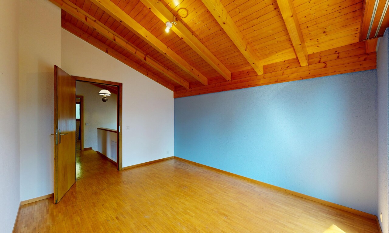 pièce vide avec vaulted ceiling, plafond voûté, beamed ceiling, plafond à poutres, et drywall