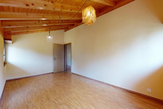 pièce vide avec drywall, cloison sèche, éclairage suspendu, beamed ceiling, et plafond à poutres