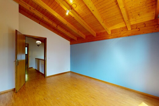 pièce vide avec vaulted ceiling, plafond voûté, beamed ceiling, plafond à poutres, et drywall