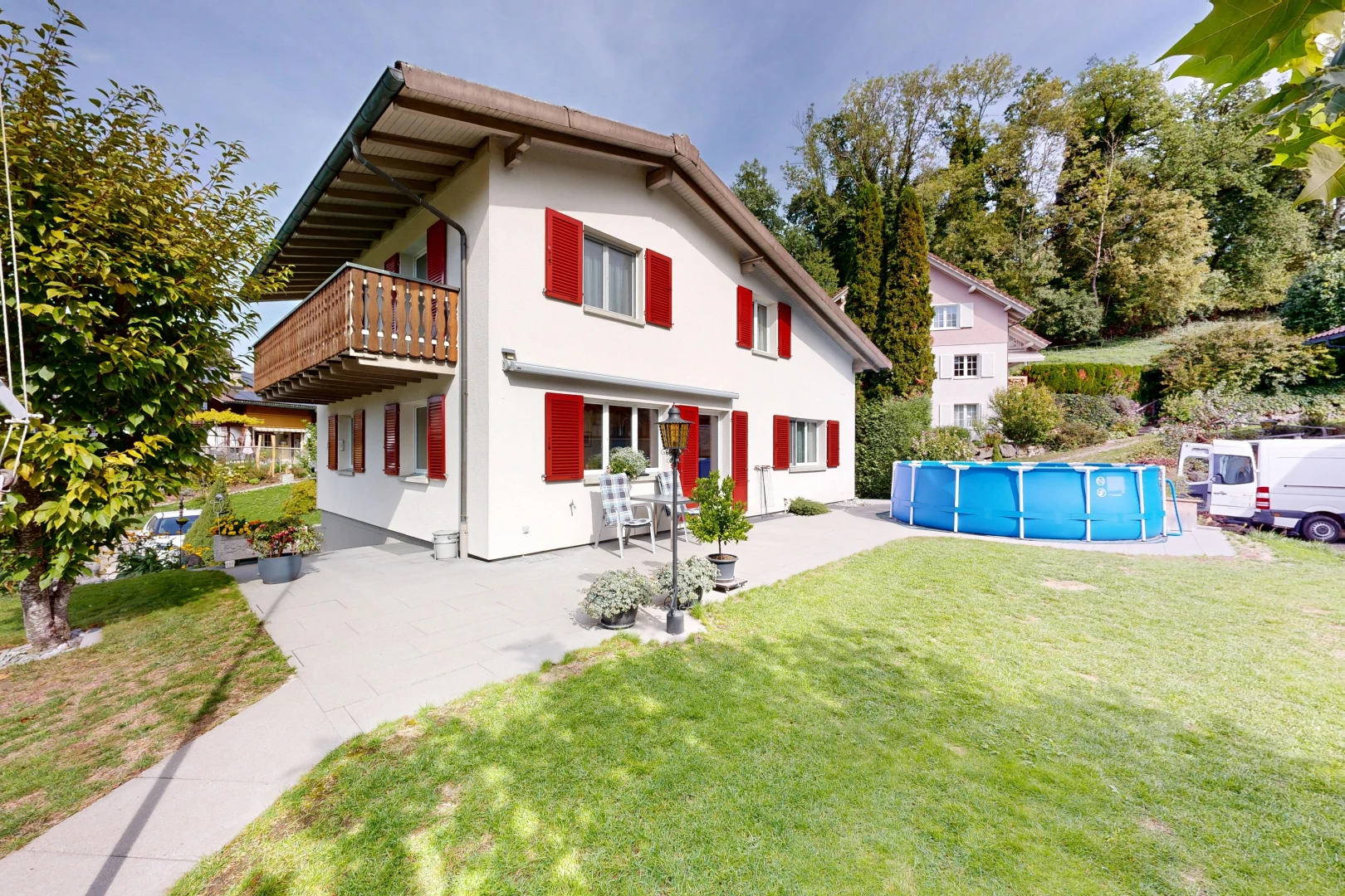 außenansicht mit balkon, schwimmbad, rasen, property visible, und stuckverkleidung