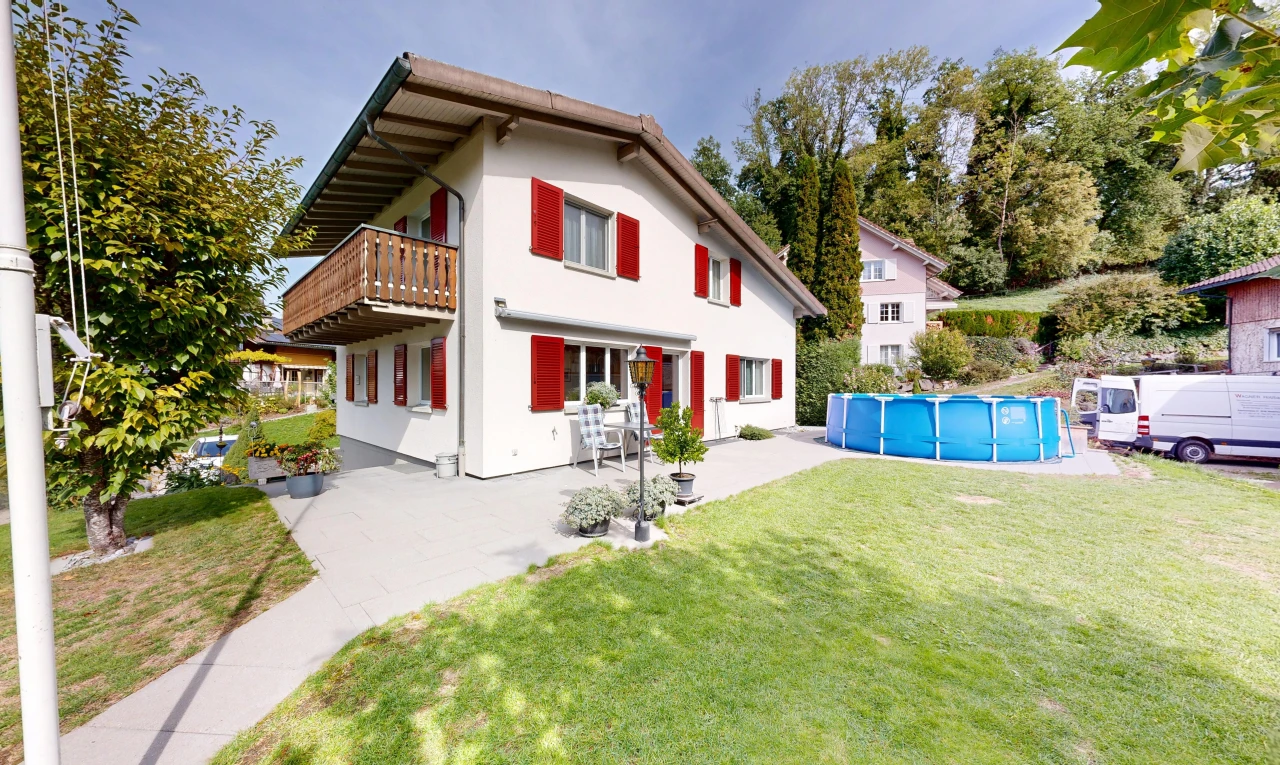 außenansicht mit balkon, schwimmbad, rasen, property visible, und stuckverkleidung